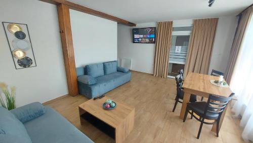 a living room with a blue couch and a table at Apartmány Podlavice in Banská Bystrica
