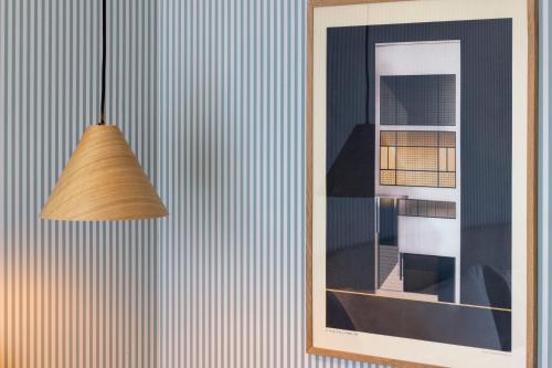 a pendant light hanging on a wall next to a mirror at Le Petit Oberkampf Hotel & Spa in Paris