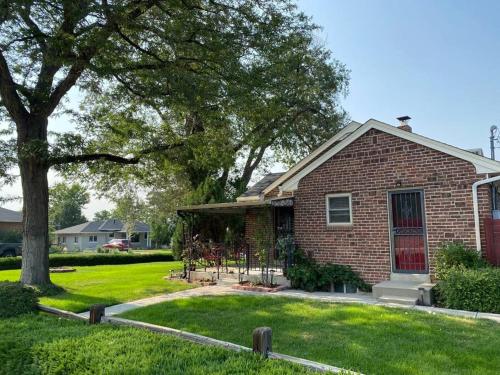 a brick house with a tree in the yard at The House You Want - Perfect location & No Chores! in Denver