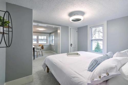 a bedroom with a large white bed and a window at New! The Docks @ Waterside - Lake Front Hot Tub! in Akron