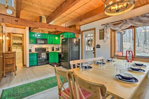 a kitchen with a wooden table and green cabinets at 4 Mi to Tubing Cozy Bushkill Cabin with Deck! in Bushkill