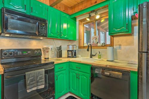 a green kitchen with a stove and a sink at 4 Mi to Tubing Cozy Bushkill Cabin with Deck! in Bushkill