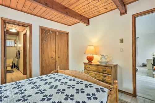 a bedroom with a bed and a dresser and a mirror at 4 Mi to Tubing Cozy Bushkill Cabin with Deck! in Bushkill