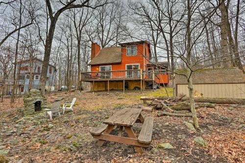an orange house with a picnic table in front of it at 4 Mi to Tubing Cozy Bushkill Cabin with Deck! in Bushkill