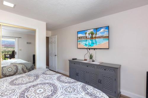 a bedroom with a bed and a tv on a wall at LP 124 Mesa Views, Grill, Cable, Great Las Palmas Amenities, and Fully Stocked Kitchen in St. George