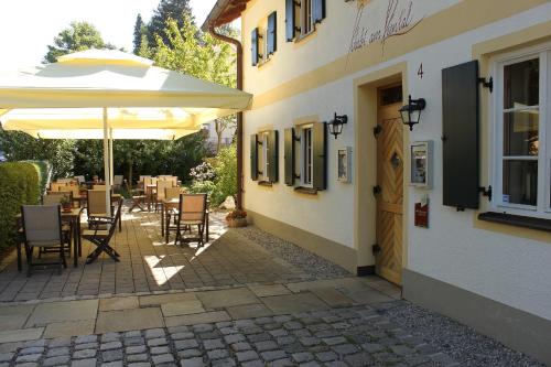 a patio with an umbrella and tables and chairs at Romantik Hotel Chalet am Kiental in Herrsching am Ammersee