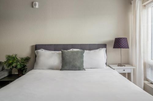 a bedroom with a large white bed and a lamp at Kasa University Avenue Minneapolis in Minneapolis