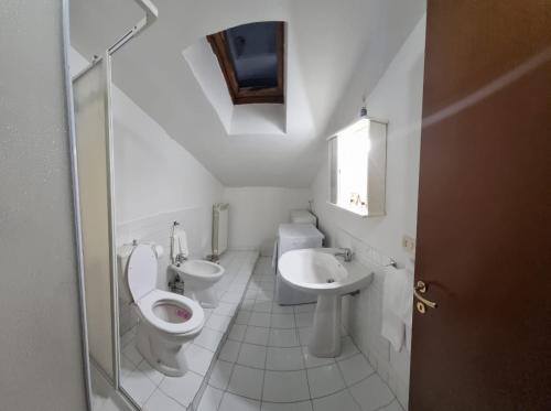 a white bathroom with a toilet and a sink at Residenza Infante in Avezzano