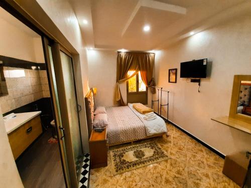 een kleine slaapkamer met een bed en een wastafel bij DARKOM in Dakhla