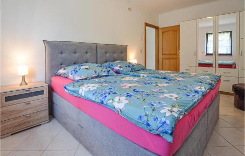 a bedroom with a large bed with a blue comforter at Awesome Apartment In Berlin-bohnsdorf With Kitchen in Berlin