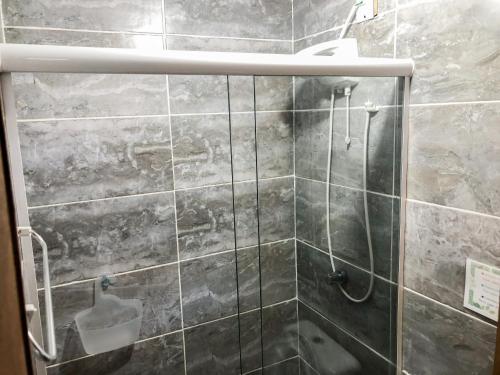 baño con ducha y puerta de cristal en Voila Hostel, en Florianópolis