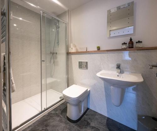 a bathroom with a shower and a toilet and a sink at Achintee Cottages No 1 in Fort William