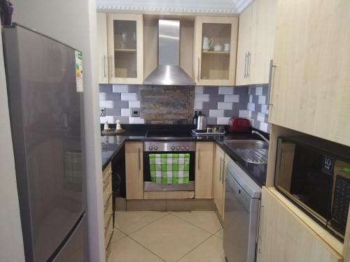 ダーバンにあるSails Luxury 1 Bedroom Apartmentのキッチン(コンロ、冷蔵庫付)