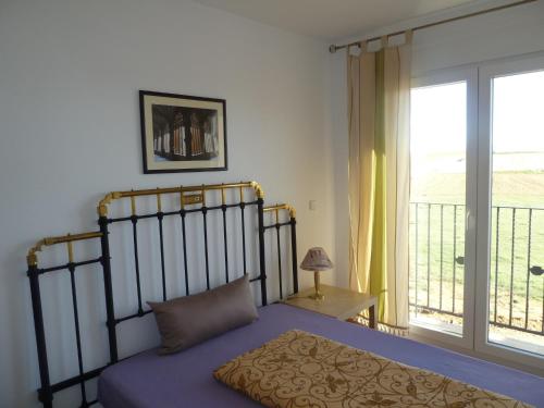 a bedroom with a bed and a balcony at Hostal Moratinos in Moratinos