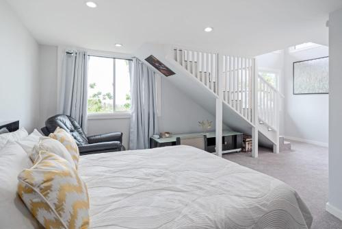 a white bedroom with a bed and a staircase at Serenity Sophistication and Stunning Views in Emerald Lake Hills