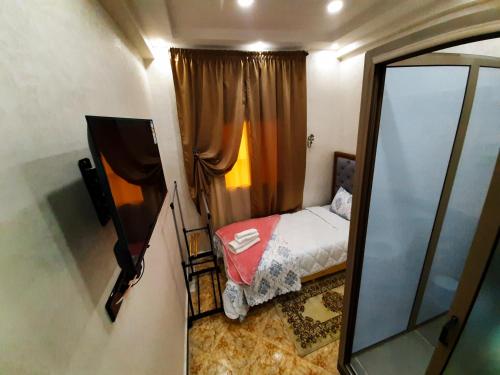 a small bedroom with a bed and a mirror at DARKOM in Dakhla