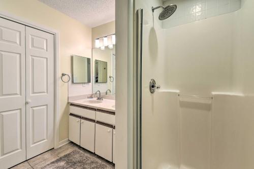 uma casa de banho branca com um chuveiro e um lavatório. em Family-Friendly Niceville Home By Golf Club! em Niceville