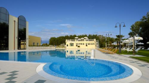 ein großer Pool mit einem Gebäude im Hintergrund in der Unterkunft Zanhotel Centergross in Bentivoglio