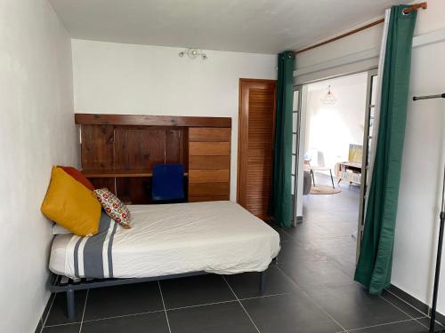 ポワンタピートルにあるAppart cosy à Pointe-à-Pitreのベッドルーム1室(ベッド1台付)、スライド式ガラスドアが備わります。