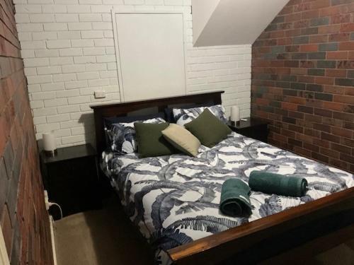 Bett in einem Zimmer mit Ziegelwand in der Unterkunft Wynyardway in Tumut