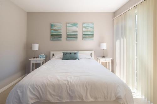 1 dormitorio blanco con 1 cama grande y 2 mesas en Bright Quiet Comfy 1BR Cottage in Mountain View, en Mountain View