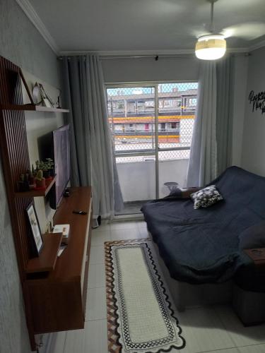 a bedroom with a bed and a window at Apto da Andreia in Praia Grande