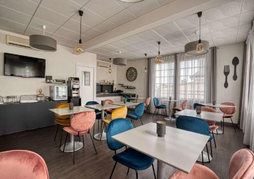 un restaurant avec des tables et des chaises et une cuisine dans l'établissement Best Western Le Vinci Loire Valley, à Amboise