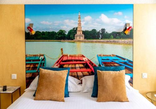 a bed with a view of a boat on a river at Best Western Le Vinci Loire Valley in Amboise