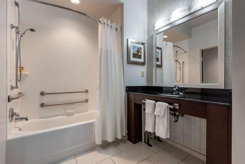 a bathroom with a bath tub and a sink at Best Western Plus The Hammondsport Hotel in Hammondsport
