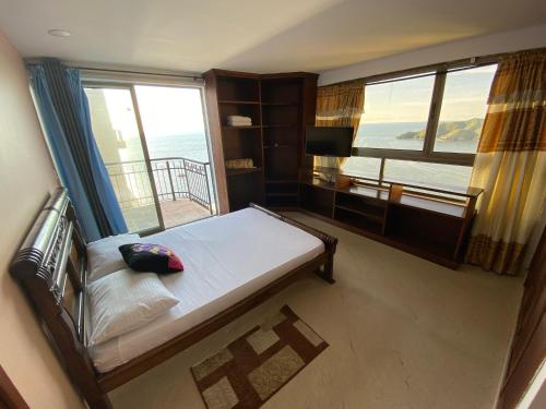 a bedroom with a bed and a large window at Apartamento Rodadero frente a la playa in Rodadero