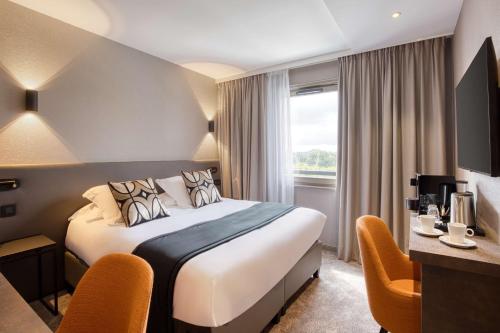 a hotel room with a bed and a desk at Best Western Plus Le Fairway Hotel & Spa Golf d'Arras in Anzin-Saint-Aubin