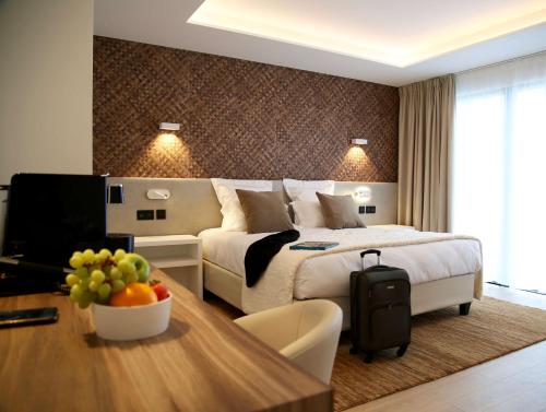 a hotel room with a bed and a table with a bowl of fruit at Best Western Plus Le Fairway Hotel & Spa Golf d'Arras in Anzin-Saint-Aubin