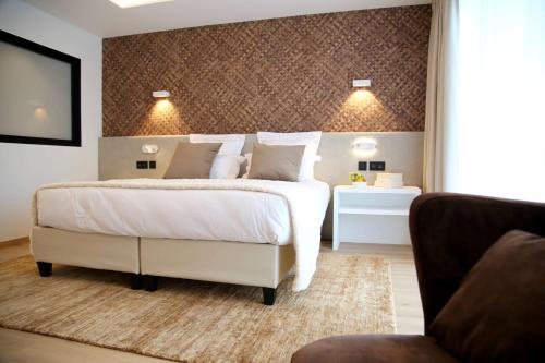 a bedroom with a large white bed and a couch at Best Western Plus Le Fairway Hotel & Spa Golf d'Arras in Anzin-Saint-Aubin