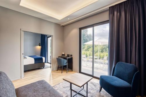 アンザン・サン・トーバンにあるBest Western Plus Le Fairway Hotel & Spa Golf d'Arrasのベッド、ソファ、椅子が備わるホテルルームです。