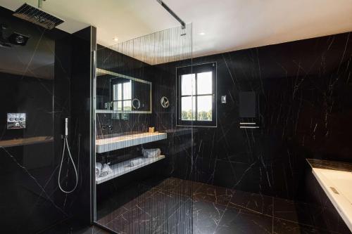 een zwarte badkamer met een douche en een raam bij Best Western Plus Le Fairway Hotel & Spa Golf d'Arras in Anzin-Saint-Aubin