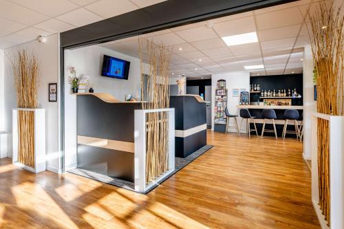 a room with a bar with a wooden floor at Sure Hotel by Best Western Bordeaux Lac in Bordeaux