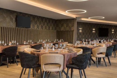 a conference room with tables and chairs and a flat screen tv at Best Western Plus Le Fairway Hotel & Spa Golf d'Arras in Anzin-Saint-Aubin