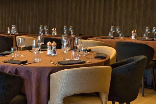 a row of tables in a restaurant with wine glasses at Best Western Plus Le Fairway Hotel & Spa Golf d'Arras in Anzin-Saint-Aubin