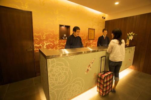 a woman standing next to a man in front of a counter at Ueno Touganeya Hotel in Tokyo