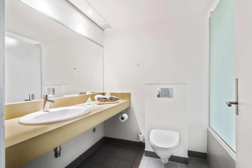 a bathroom with a sink and a toilet at Hotel Sonderborg Strand; Sure Hotel Collection by Best Western in Sønderborg