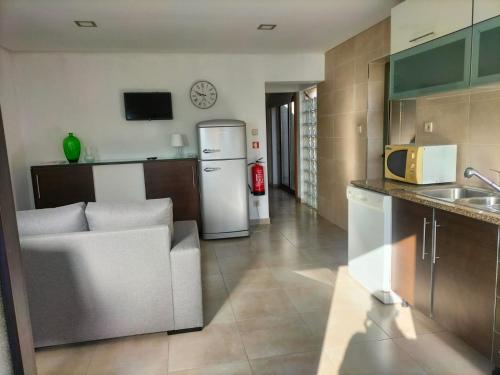 a kitchen with a couch and a refrigerator at The Ferry House in São Jacinto