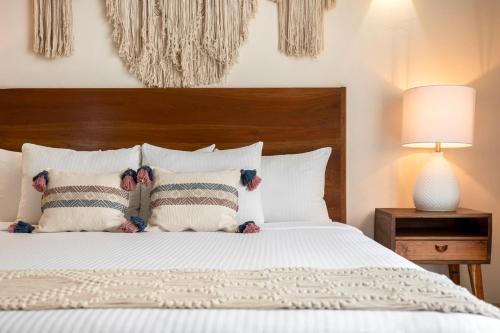 a bedroom with a bed with a wooden headboard and pillows at Le Muuch Hotel Boutique in Valladolid