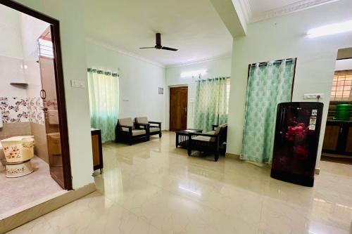 a living room with a couch and a chair in a room at TrueLife Comfort Inn - Near PS4 veg restaurant - On way to Balaji Temple - 2BHK AC apartments - Coffee Tea Milk - Fast WiFi, Kitchen, Dining, Android TV, Parking - Easy access to Airport, Railway Station and to all Temples - Top service with lots of Love in Tirupati