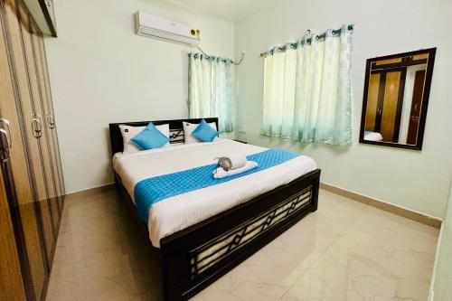 a bedroom with a bed with a stuffed animal on it at TrueLife Homestays - SRS Residency - 2BHK AC apartments for families visiting Tirupati Temple - Fast WiFi, Kitchen, Android TV - Walk to PS4 Pure Veg Restaurant, Mayabazar Super Market - Easy access to Airport, Railway Station, All Temples in Tirupati