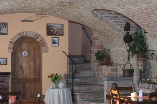 a dining room with a brick wall and a wooden door at Il Borgo B&B in Castellinaldo