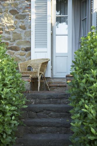 a wicker bench sitting on the front porch of a house at La Locanda Volpaia in Radda in Chianti