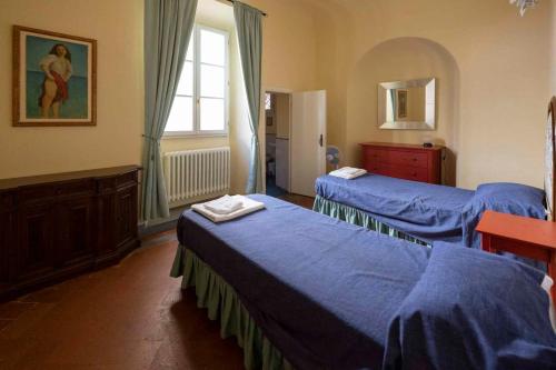 una camera con due letti con lenzuola blu e una finestra di Holiday home in Florenz - Toskana 43634 a Firenze
