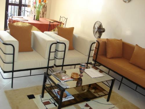 a living room with three couches and a coffee table at Délices Chez l'Habitant Diack in Dakar