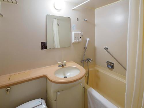 La salle de bains est pourvue d'un lavabo, de toilettes et d'un miroir. dans l'établissement Airline Hotel, à Miyazaki