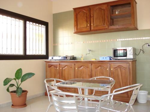 a kitchen with a table and chairs and a microwave at Délices Chez l'Habitant Diack in Dakar